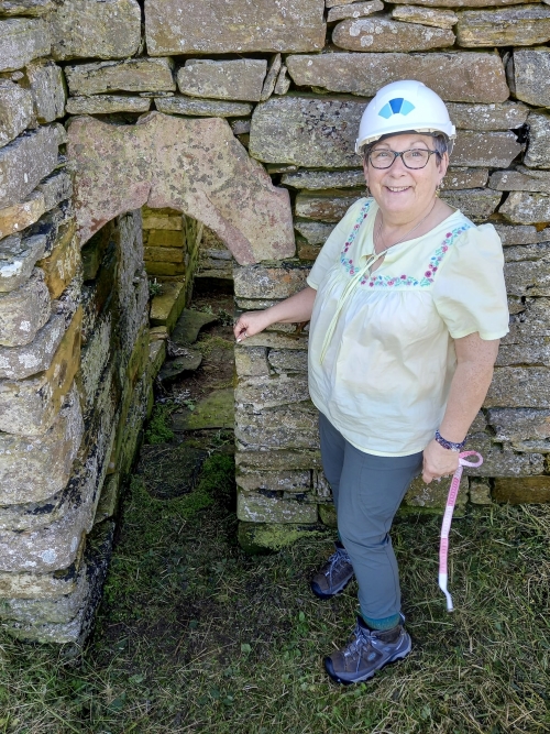 Jenny Murray surveying red sandstone fragments in the Eynhallow church, Orkney, as part of her ongoing PhD research.